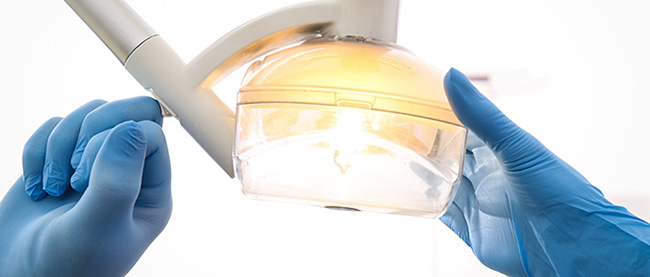 Manos de médico cirujano con lámpara quirúrgica