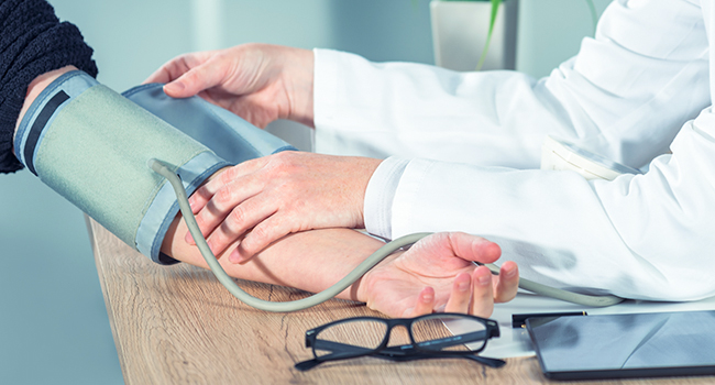 Doctor tomando la presión al paciente.