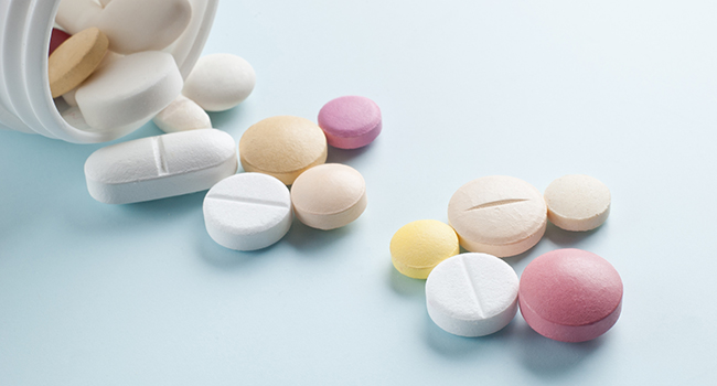 Pastillas saliéndose de un pastillero.